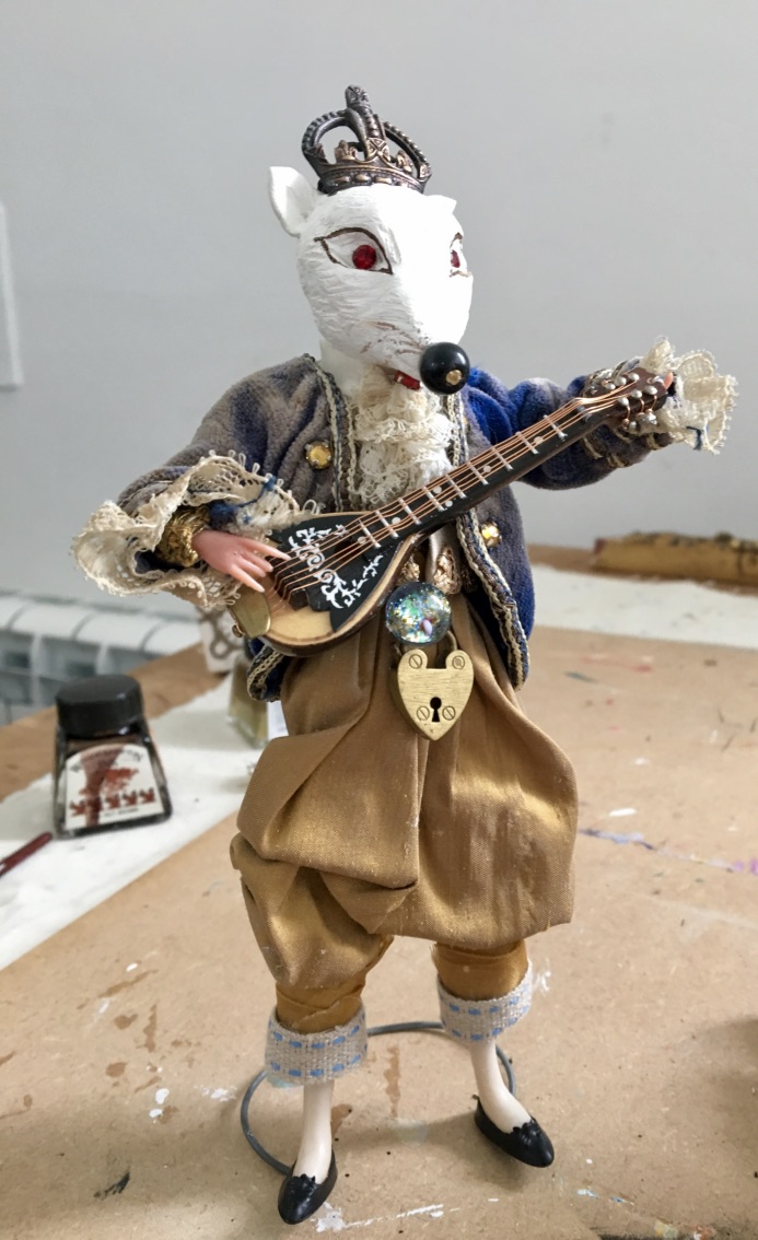 Handmade fox musician figure wearing a crown and holding a small instrument.