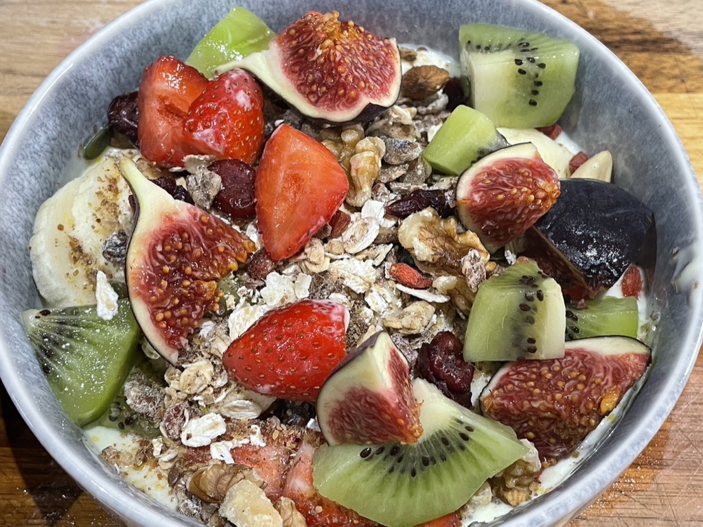 Breakfast oats topped with kiwi, figs, banana, strawberries, walnuts and dried fruit.