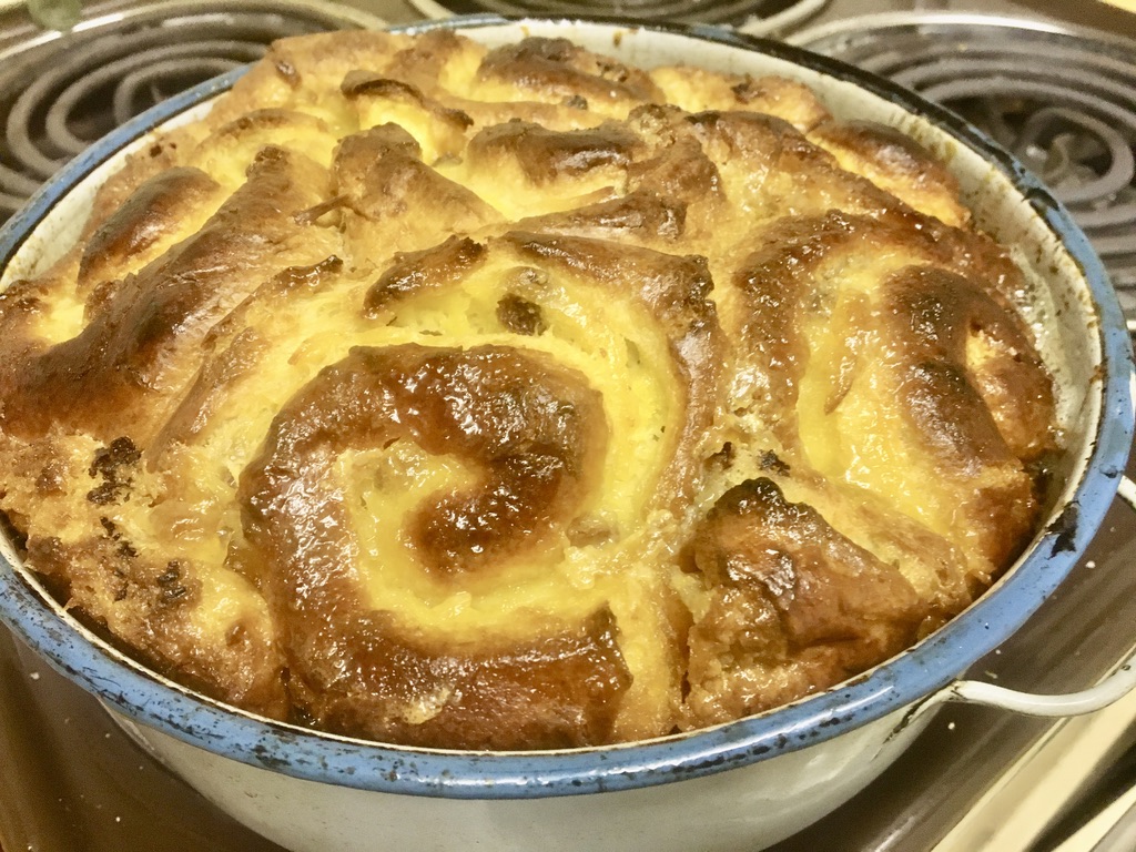 Golden baked bread and butter pudding made with cinnamon swirls, custard and marmalade.